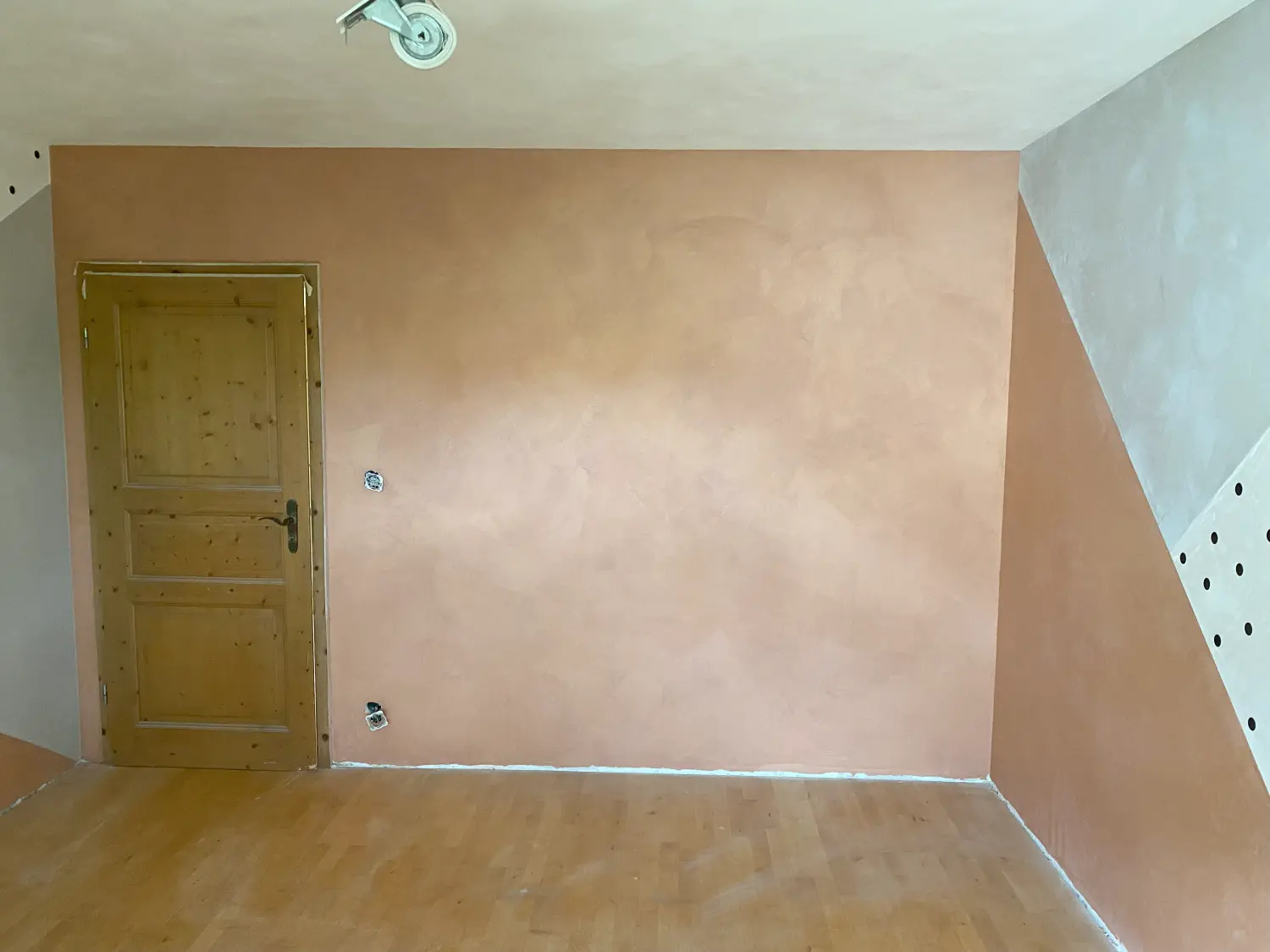 Dachgeschosszimmer mit terrakottafarbener Akzentwand